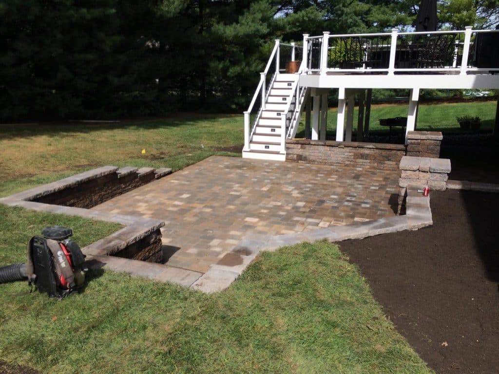 picture of stone patio with stairs up to deck