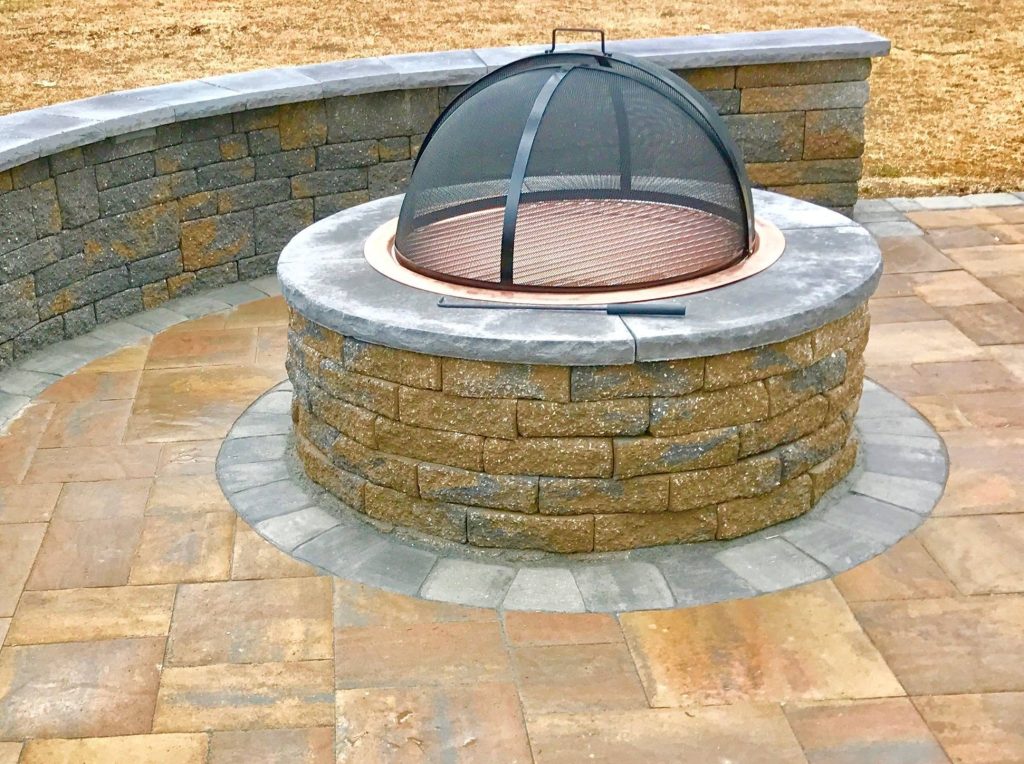 Firepit on stone patio with wall/seating